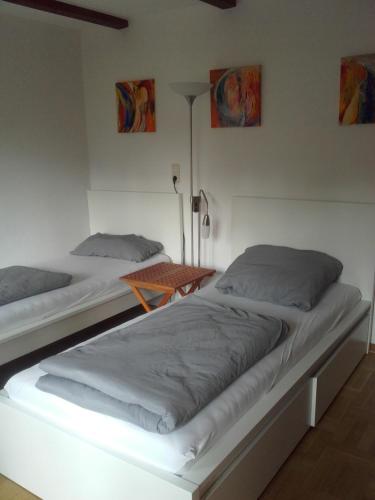 2 letti in una camera bianca con lampada di Apartment-unter-Reet a Kiel