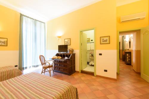 a bedroom with a bed and a desk and a mirror at Hotel Mergellina in Naples