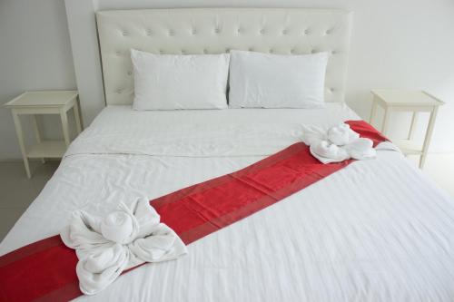 a white bed with red and white bows on it at The Pool Resort in Bangkok
