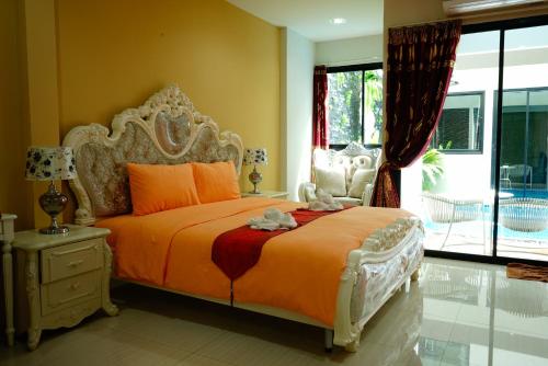 a bedroom with a large bed with an orange bedspread at The Pool Resort in Bangkok