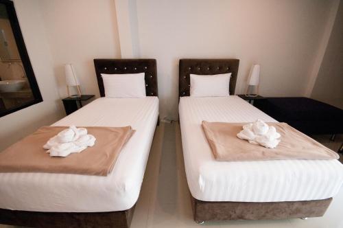 two beds in a room with towels on them at The Pool Resort in Bangkok