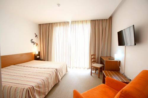 Habitación de hotel con cama y sofá en Evenia Monte Real, en Monte Real