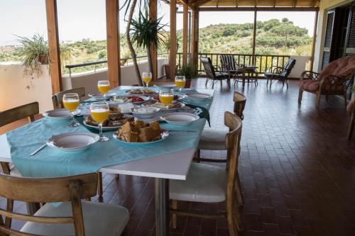 una mesa con un plato de comida y vasos de zumo de naranja en Alexandra Villa Stalos en Stalos