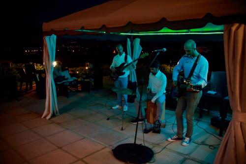 a group of people playing music on a stage at Abbaidda Hotel in Valledoria