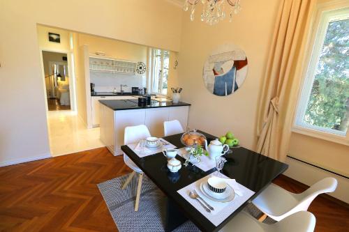 a dining room with a black table and white chairs at Apartment MiraMare on the beach in Split