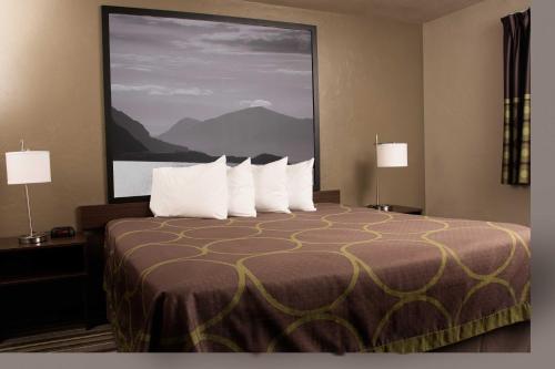 a hotel room with a large bed with white pillows at Super 8 by Wyndham Juneau in Juneau