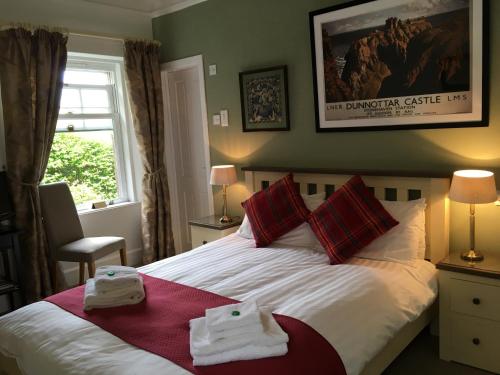 een slaapkamer met een bed met handdoeken erop bij Arduthie House in Stonehaven