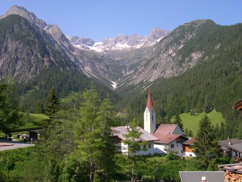 a church in the middle of a valley with mountains at Lechtaler Naturparkchalets in Gramais