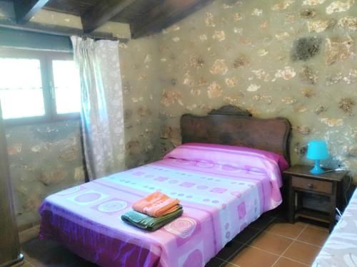 1 dormitorio con 1 cama con colcha rosa en Casa Rural en Aldea Cueva Ahumada, en Villaverde de Guadalimar