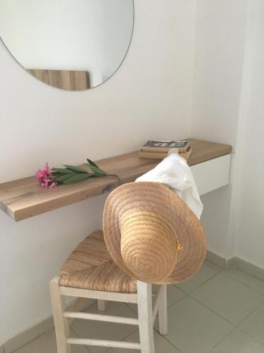 a rattan chair in a room with a mirror at CAELI PAROS by Kostas & Joanna Studios in Logaras