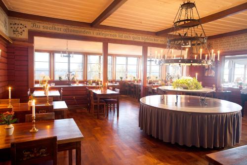 a restaurant with tables and chairs and a chandelier at Tällbergsgårdens Hotell in Tällberg