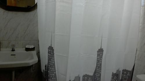 a bathroom with a shower curtain with a city at Hospedaje de Lidia in Lima