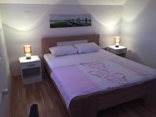 a bedroom with a large bed with two night stands at Apartments Premović Nikšić in Nikšić