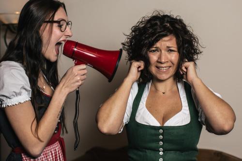 two women shouting through a megaphone at Hotel Die Arlbergerin - Design & Tiroler Gemütlichkeit in Sankt Anton am Arlberg