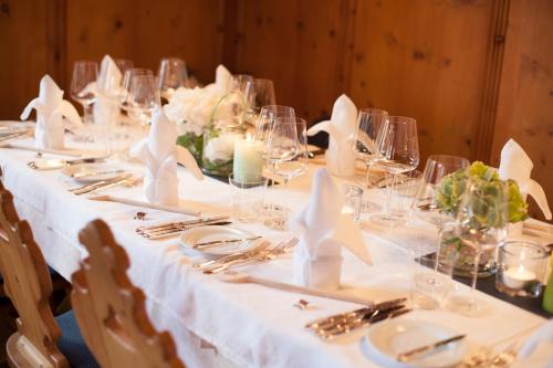a long table with white tablecloths and napkins at Hotel Die Arlbergerin - Design & Tiroler Gemütlichkeit in Sankt Anton am Arlberg