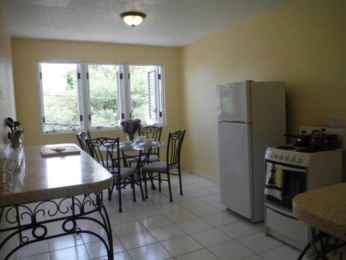 a kitchen with a table and a white refrigerator at Posada Colonial Beach Villas in San Juan