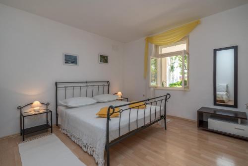 - une chambre avec un lit, une commode et une fenêtre dans l'établissement Apartments in Trogir, à Trogir