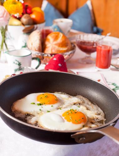 two eggs are frying in a pan on a table at Hotel Die Arlbergerin - Design & Tiroler Gemütlichkeit in Sankt Anton am Arlberg