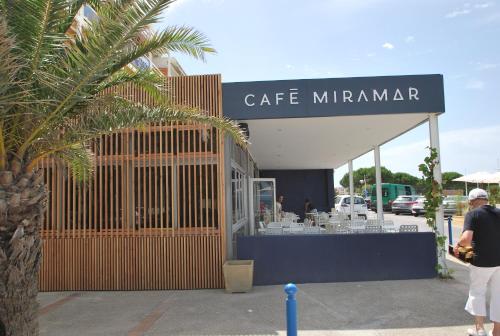 a man standing in front of a coffee shop at Hôtel Café Miramar in Le Grau-du-Roi