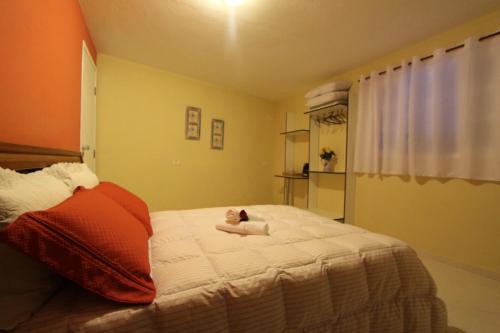 a bedroom with a bed with a teddy bear on it at Pousada Porto Paraiso, o seu Paraíso Escondido no Guarujá in Guarujá