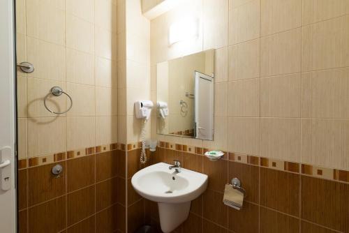 ein Bad mit einem Waschbecken und einem Spiegel in der Unterkunft Family Hotel Dayana Beach in Sinemorets