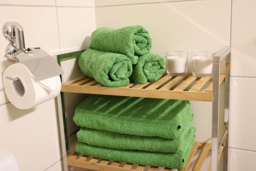 La salle de bains est pourvue de serviettes vertes et de toilettes. dans l'établissement Paul's Studio, à Kaprun