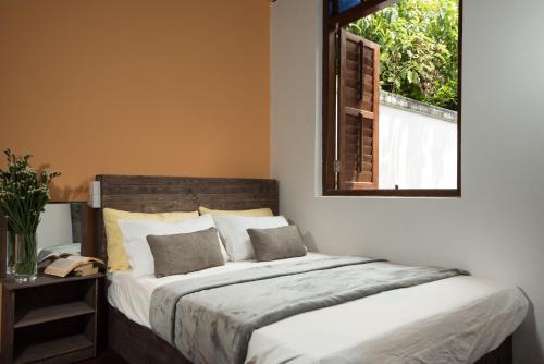 a bedroom with a large bed with a window at Rope Walk Guest House in George Town