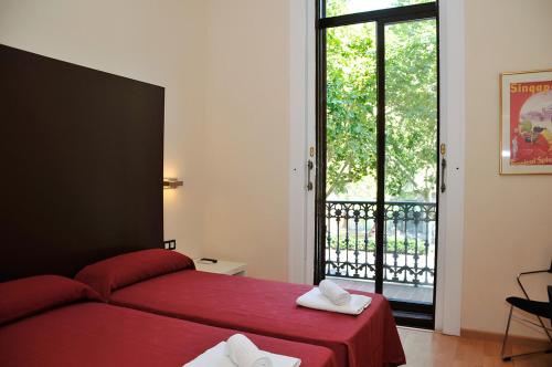 a bedroom with a red bed and a large window at Center Gran Via in Barcelona