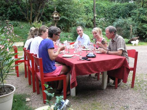 a group of people sitting at a red table at Chambre d'hôtes du Moulin de Landonvillers in Courcelles-Chaussy