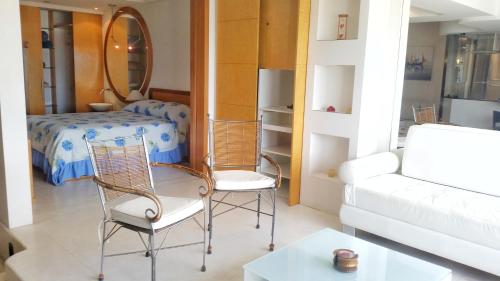 - un salon avec un canapé et deux chaises dans l'établissement Barramares Flat, à Rio de Janeiro