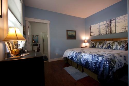 a bedroom with a bed and a lamp on a desk at Salmon Point B&B in Oyster Bay
