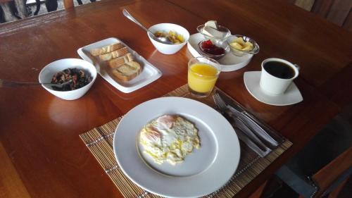 a table with a plate of breakfast foods and drinks at Finca Queveri in Orosí