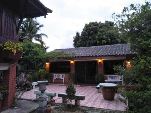 a house with a patio with benches and lights at Oui Kaew Homestay in Phayao