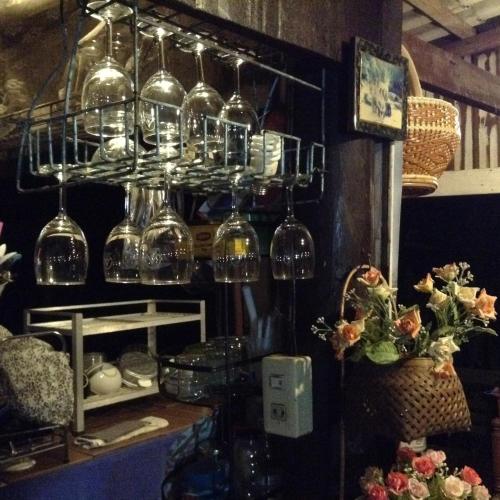 a bunch of wine glasses hanging from a shelf at Oui Kaew Homestay in Phayao