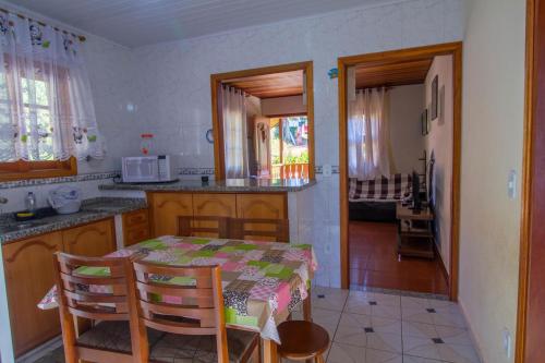 a kitchen with a table and chairs and a kitchen with a table and a kitchen at Casa Pau Brasil in Monte Verde