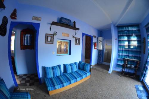 a living room with blue walls and a blue couch at Dar Besmellah in Chefchaouene