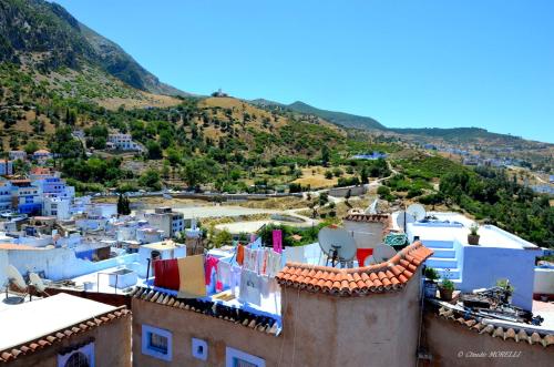 a view of a town with mountains in the background at Dar Besmellah in Chefchaouene