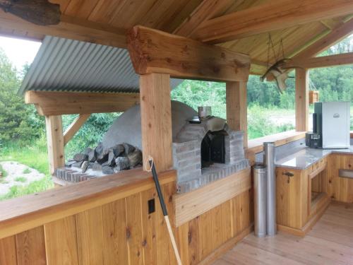 an outdoor kitchen with a stone oven in a cabin at LDR Lodge - Last Dollar Ranch in Smithers