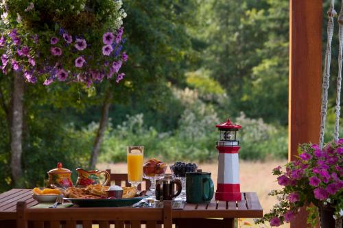 a table with a plate of food and a lighthouse at Salmon Point B&B in Oyster Bay