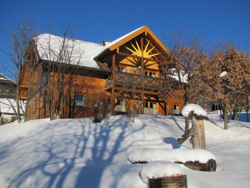 a large wooden house with snow on the ground at Familien-Appartements Örglwirt's Gut in Mariapfarr