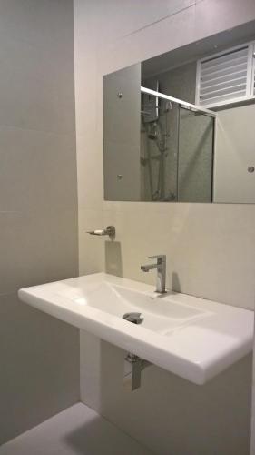 a bathroom with a white sink and a mirror at The Nest by Amarasinghe's in Haputale