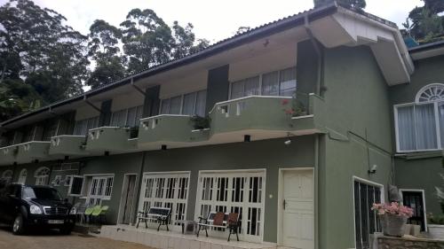 a green building with a car parked in front of it at The Nest by Amarasinghe's in Haputale