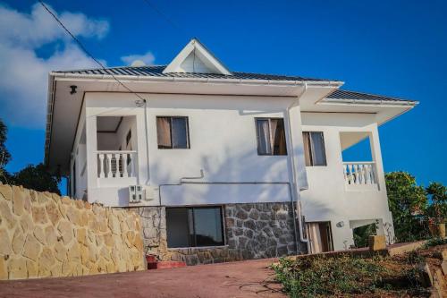 a white house with a stone wall at Horizon view in Victoria
