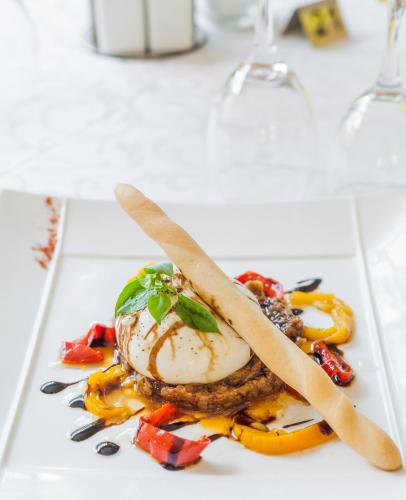 a plate of food with eggs and peppers on a table at The Originals City, Hôtel Les Bastides du Gapeau in Solliès-Toucas
