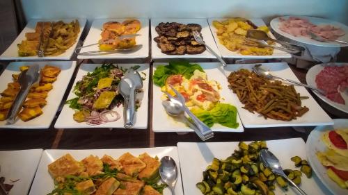 a table full of different types of food on plates at Hotel Lungomare in Cesenatico