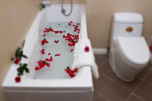a bathroom with a toilet with red flowers on it at Orchid Boutique Beach Resort in Phan Thiet