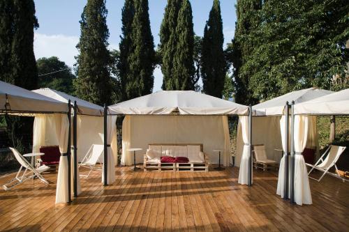 a patio area with chairs, tables and umbrellas at Agriturismo La Topaia in Borgo San Lorenzo