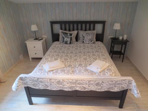 a bedroom with a large bed with two pillows at Mizarai Mill House in Druskininkai