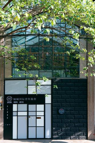 a building with two garage doors in front of it at Kunming Upland International Youth Hostel ,near the city center ,2 mins walk to the subway, 2 mins walk to the Green Lake, Close to Yuan tong Temple, Old street, Yunnan University, convenient payment and visa cards are accepted in Kunming