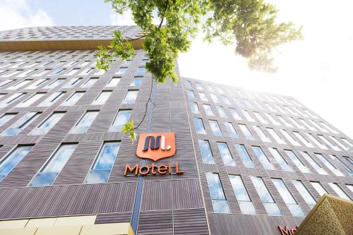 a building with a motel sign in front of it at Motel L Stockholm Älvsjö in Stockholm